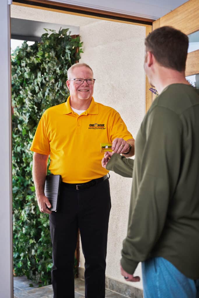 One Hour Air Conditioning & Heating technician greeting a homeowner at the front door