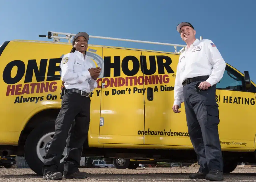 One Hour Air Conditioning & Heating technicians beside a branded service vehicle