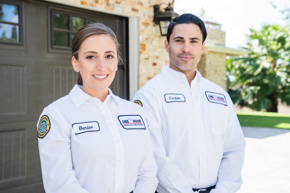 Two One Hour Air Conditioning & Heating technicians standing outside a residential home in uniform